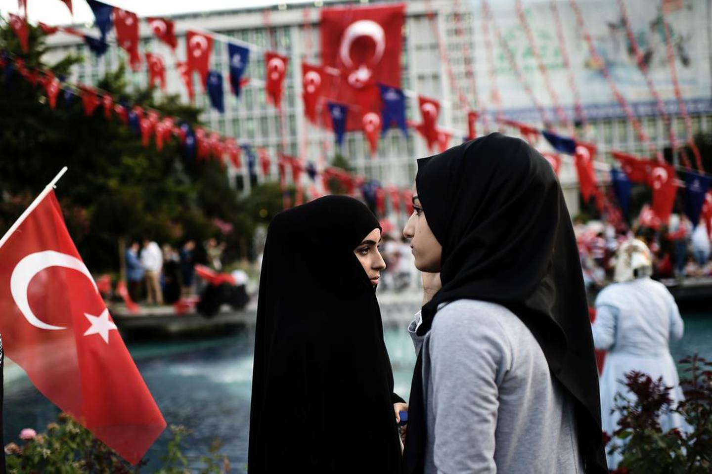 Zwei junge Frauen mit Kopftuch nehmen an einer regierungsnahen Demonstration vor dem Rathaus in Istanbul teil.  AFP