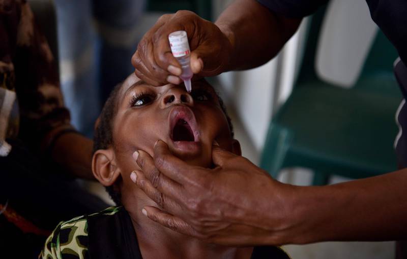 Photo taken on November 22, 2018 shows six-year-old Warapnong Ponde recieving a polio vaccination from health worker Margaret Akima in her mobile clinic on a street in Mount Hagen in the Western Highlands.  Decades after polio was eradicated from Papua New Guinea, the crippling and sometimes deadly disease has returned, leaving doctors scrambling to resuscitate long-lapsed vaccination programmes. - TO GO WITH: PNG-health-disease-virus-vaccine-polio, by Andrew BEATTY
 / AFP / PETER PARKS / TO GO WITH: PNG-health-disease-virus-vaccine-polio, by Andrew BEATTY
