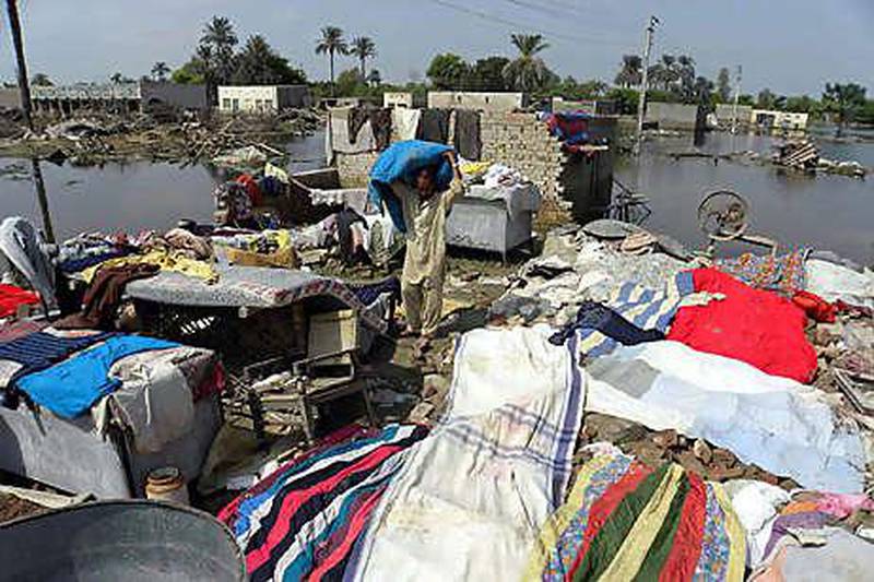 People search for their belongings amid remains of a house destroyed by the floods as they return to their village in Kasba Gujrat, near Muzaffargarh, in Punjab province.