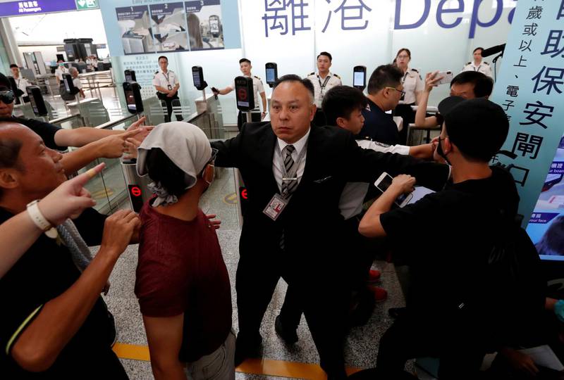 A member of the airport staff tries to stop anti-government protesters during a demonstration at Hong Kong Airport. Reuters