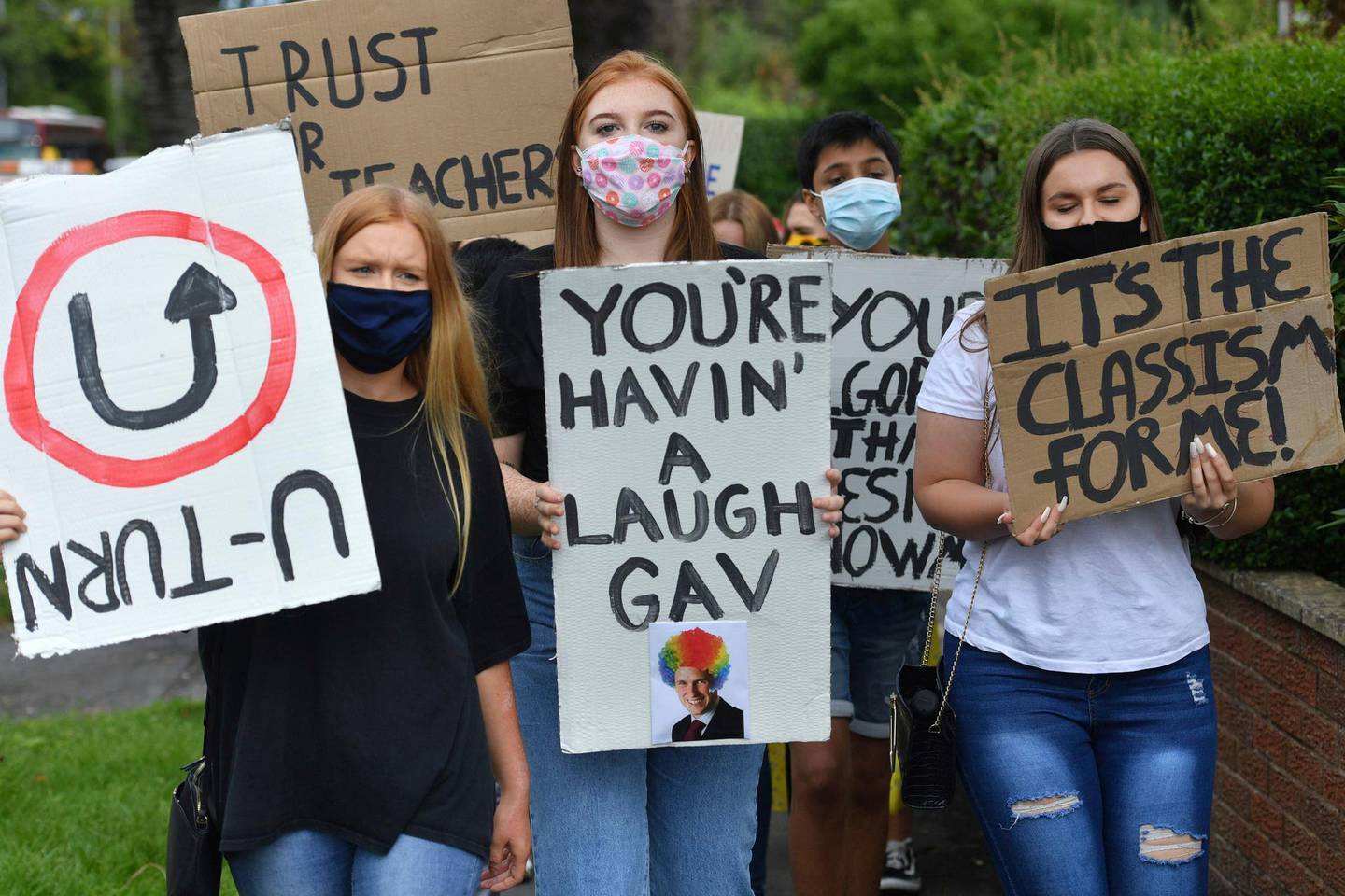 Students march to the constituency office of their local lawmaker, Education Secretary Gavin Williamson, in South Staffordshire, England, Monday Aug. 17, 2020.  Students are protesting over the government's handling of A-level results, using an algorithm to work out marks, with many students receiving lower than expected grades after their exams were cancelled because of the coronavirus restrictions. (Jacob King/PA via AP)