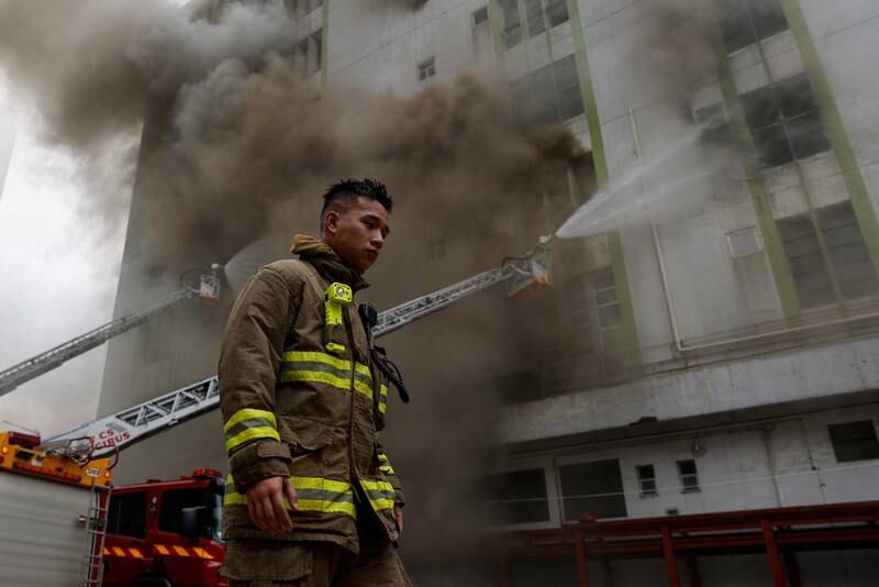 A firefighter walks next to a blaze at a warehouse in Hong Kong's Kowloon district. Reuters