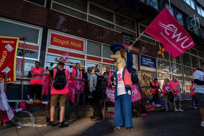 A striking postal worker dressed as the cartoon character Postman Pat on a picket line outside the Whitechapel delivery office in London. Bloomberg