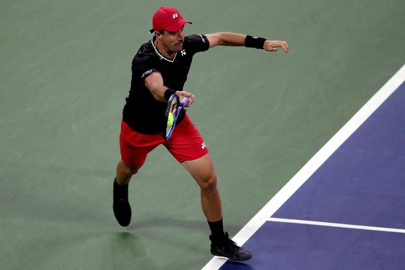 Steve Johnson of the United States lunges for a ball during his Men's Singles first round match against John Isner of the United States.  AFP