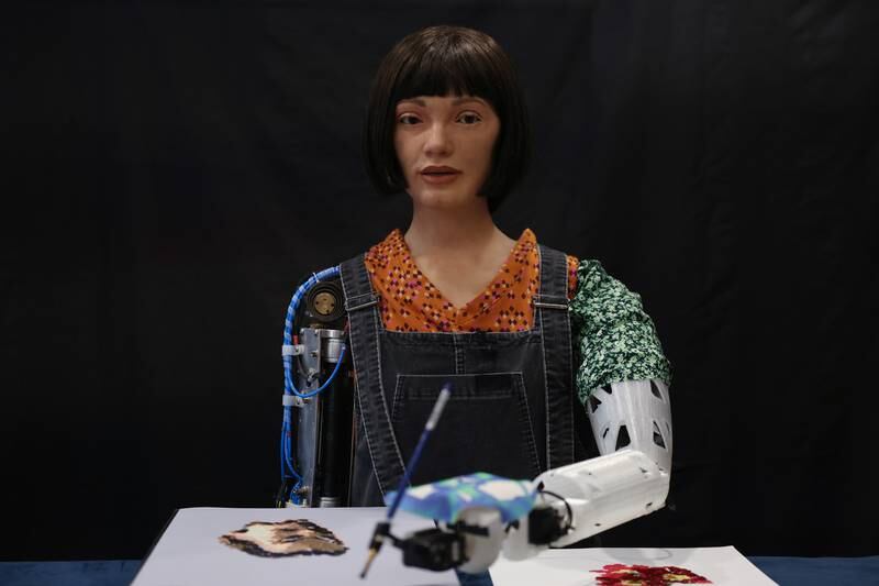 Ai-Da Robot, an ultra-realistic humanoid robot artist, paints during a press call at The British Library on Monday. Getty Images