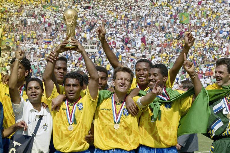 Romario (with trophy) and captain Dunga of Brazil and the Brazilian team celebrate after winning the1994 FIFA World Cup Final against Italy on 17 July 1994 played at the Rose Bowl in Pasadena, California, United States. Brazil defeated Italy 3-2 in a penalty shootout.(Photo by Ben Radford/Getty Images) 