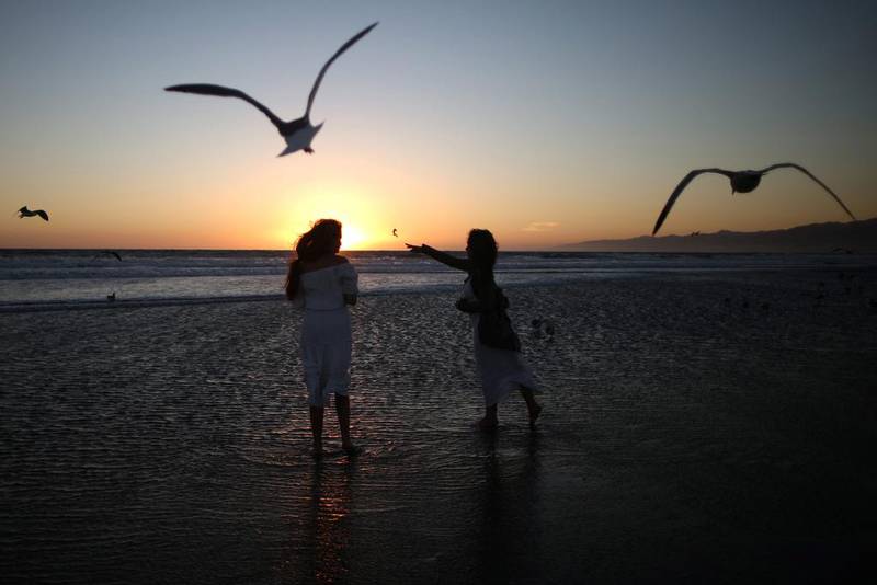 Girls throw bread crumbs into the Pacific Ocean during the Tashlich prayer, a Rosh Hashanah ritual to symbolically cast away sins, during the Nashuva Spiritual Community Jewish New Year celebration on Venice Beach in Los Angeles, California. Lucy Nicholson / Reuters