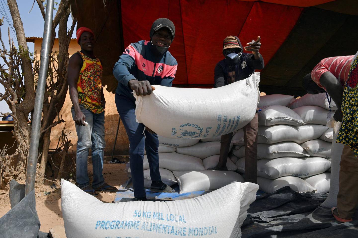 FILE PHOTO: Workers carry the aid provided by the World Food Programme (WFP) for distribution in Pissila, Burkina Faso January 24, 2020. Picture taken January 24, 2020. REUTERS/Anne Mimault/File Photo