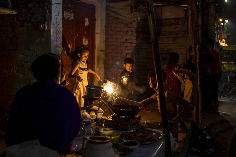 A roadside vendor lights up a firecracker on a gas stove in New Delhi. AP Photo