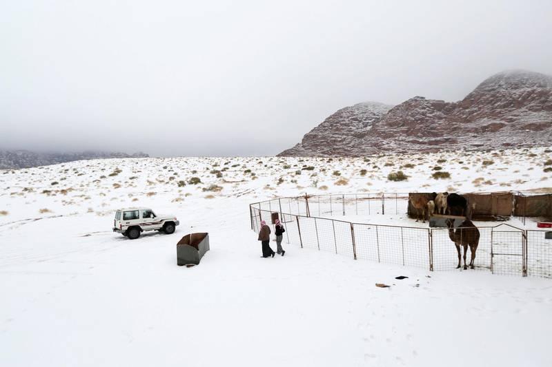 Saudis walk over snow after a heavy snowstorm in the desert near Tabuk, northwest of Riyadh February 21, 2015. REUTERS/Mohamed Alhwaity (SAUDI ARABIA - Tags: ENVIRONMENT SOCIETY)