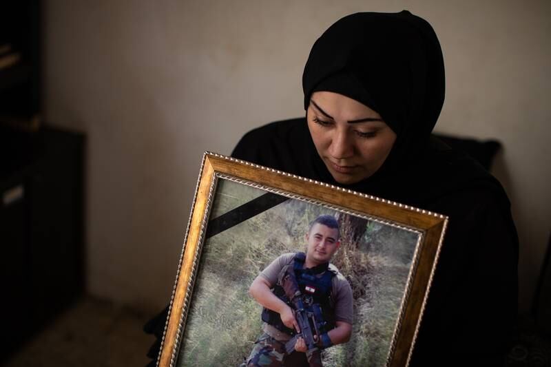 Salam Iskandar holds a photograph of her brother, Hamza, on her lap.