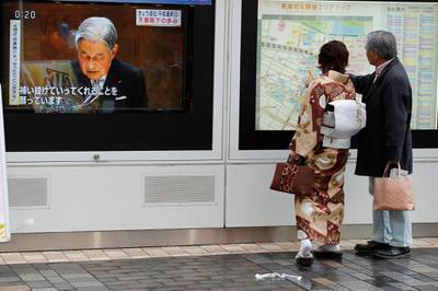 People look at a map next to the screening of a news report on Emperor Akihito in Tokyo, Japan. Reuters