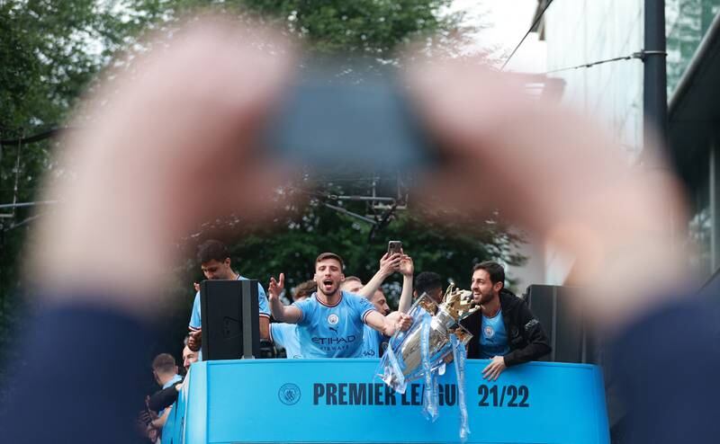 City's Ruben Dias and Bernardo Silva celebrate with the Premier League trophy. Reuters