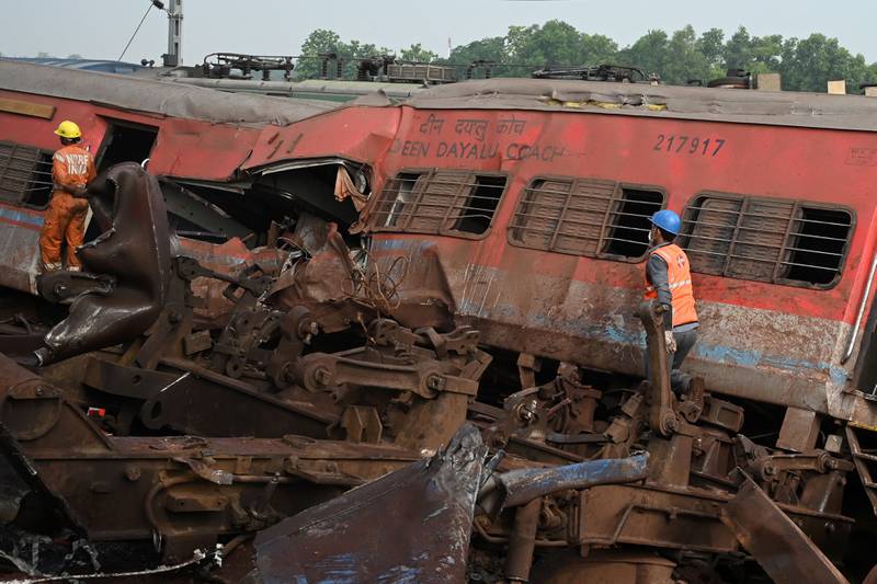 Rescue workers search for survivors amid the wreckage of carriages at the site of a three-train collision near Balasore in Odisha. AFP