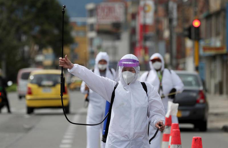 Mary Luz Hernandez, 34, a professional seamstress, holds up her spray gun to offer passing cars her disinfecting service, amid the spread of the new coronavirus in Bogota, Colombia. AP Photo