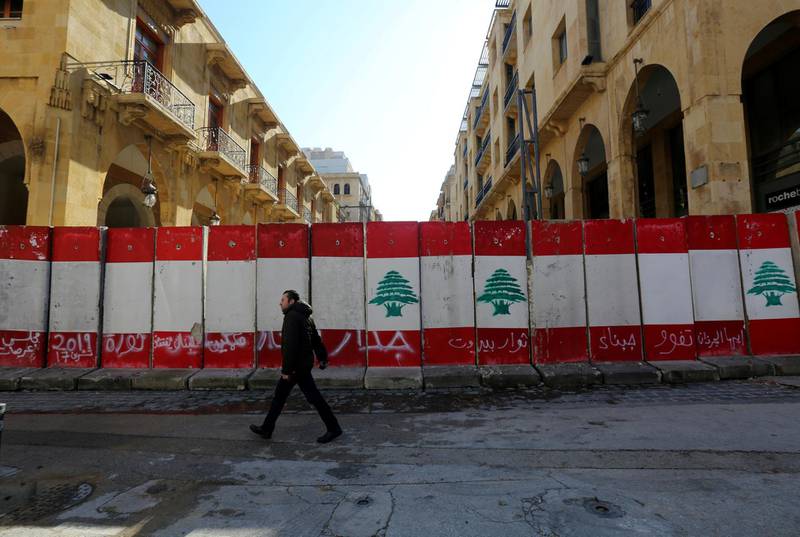 FILE PHOTO: A man walks past concrete barriers erected by authorities to block a street leading to the parliament building in Beirut, Lebanon January 24, 2020. REUTERS/Aziz Taher/File Photo