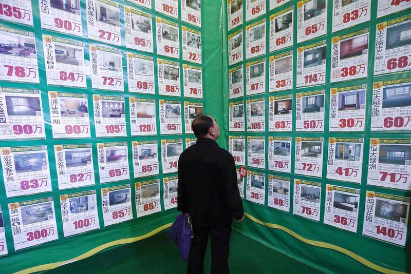 A man looks at posters on a giant advertising board showing information on second-hand apartments at a real estate exhibition in Shenyang, Liaoning province. China's real estate investment rose 16.8 per cent in the first three months of 2014 from a year earlier, and revenues from property sales dropped an annual 5.2 percent, the National Bureau of Statistics said on Wednesday. (Reuters /  April 17, 2014)