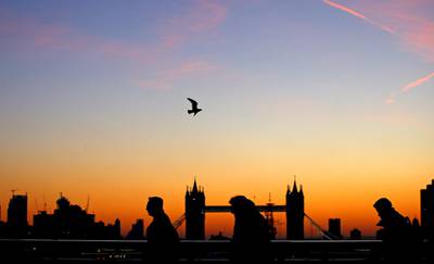 Dawn silhouettes Tower Bridge and commuters crossing the River Thames in London, Britain. Reuters