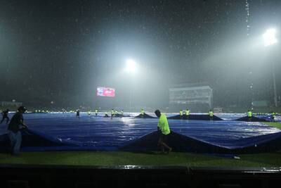The ground staff cover up the pitch after rain stopped play. Getty 