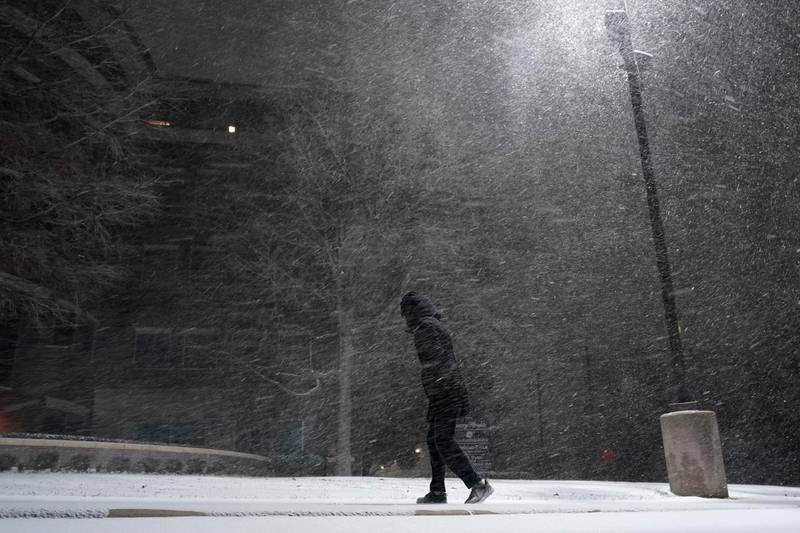 A woman walks through falling snow in San Antonio. AP