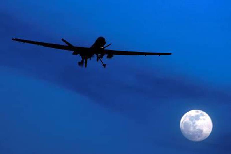 FILE - In this Jan. 31, 2010 file photo, a U.S. Predator drone flies over the moon above Kandahar Air Field, southern Afghanistan. U.S. missiles hit a suspected militant hide-out killing 16 insurgents in a troubled Pakistani tribal region along the Afghan border before dawn Saturday July 24, 2020, intelligence officials said. Six missiles struck a compound in the Nazai Narai area of South Waziristan. (AP Photo/Kirsty Wigglesworth, File)
