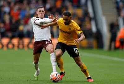 Manchester City's Phil Foden, left, and Wolves' Matheus Cunha fight for the ball. PA