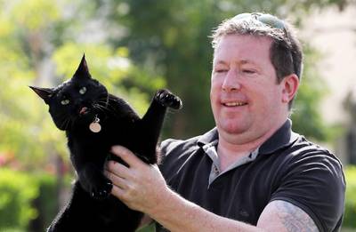 ABU DHABI , UNITED ARAB EMIRATES , DEC 10  – 2017 :- Jon Edwards with cat Smudge at his villa in Al Ghadeer Village in Abu Dhabi. Cat Smudge was missing for one week and later found in Shamkha area. (Pawan Singh / The National) Story by Ashleigh Stewart