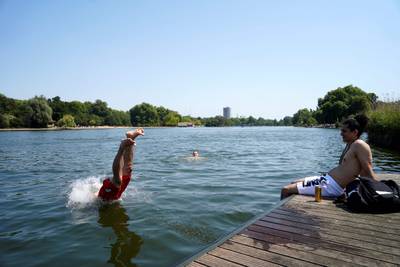 A man dives into the Serpentine Lake to cool off in Hyde Park, west London. AFP