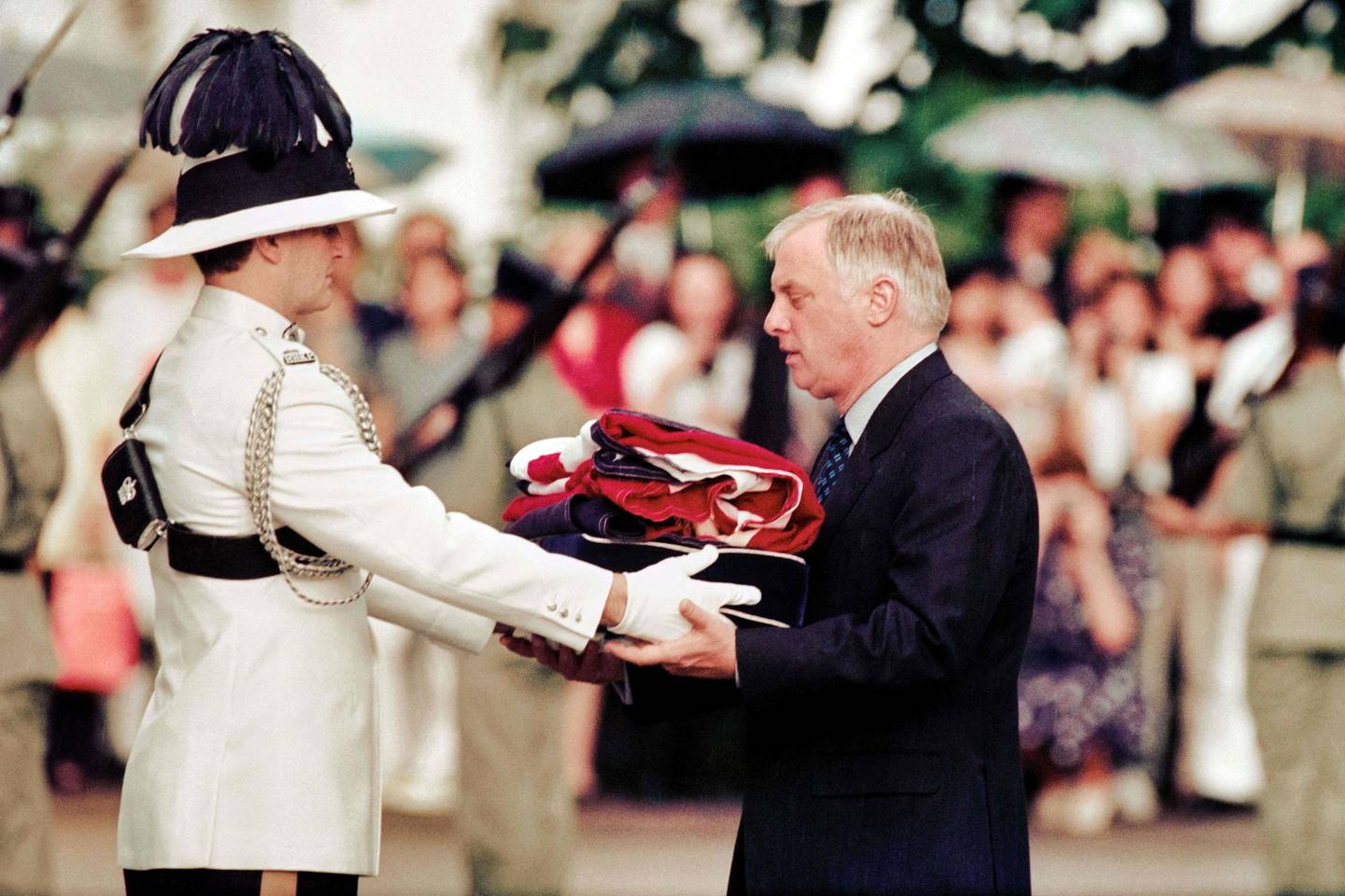 Chris Patten, the last governor of colonial Hong Kong, receives the Union Jack flag after it was lowered for the last time at Government House during a farewell ceremony in Hong Kong on July 1, 1997. AFP