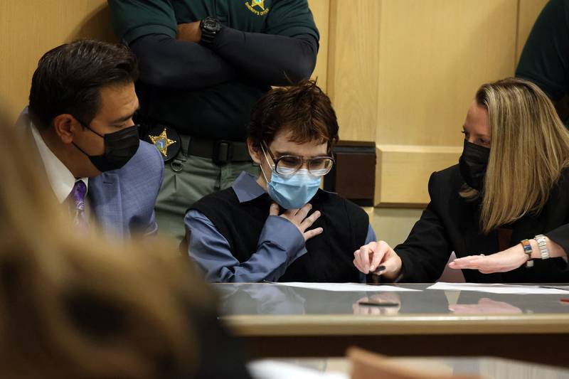 Marjory Stoneman Douglas High School shooter Nikolas Cruz puts his hand to his chest while his lawyers ask him to sign a document, on October 20, in Fort Lauderdale, Florida. Cruz pleaded guilty to all 17 counts of premeditated murder and 17 counts of attempted murder in the 2018 shooting in Parkland, Florida.  Getty Images / AFP
