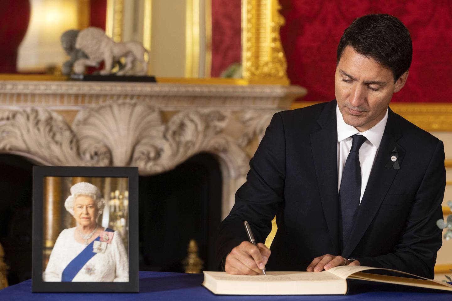 Prime Minister Justin Trudeau of Canada signs a book of condolence at Lancaster House, in London. AP