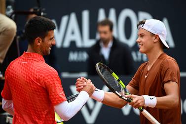 TOPSHOT - Denmark's Holger Rune (R) and Serbia's Novak Djokovic shake hands after Rune won their quarterfinals match of the Men's ATP Rome Open tennis tournament at Foro Italico in Rome on May 17, 2023.  (Photo by Filippo MONTEFORTE  /  AFP)