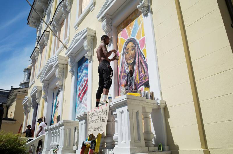 Shawn Perkins, curated by Paints Institute, paints a mural on the boarded-up windows of St. John's Church as a work of art activism for racial justice at Black Lives Matter Plaza in Washington, U.S. REUTERS