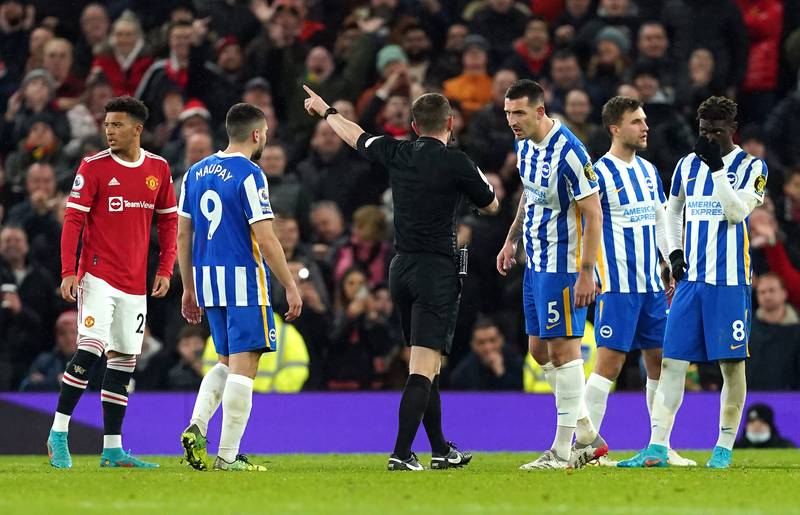 Referee Peter Bankes shows a red card to Brighton's Lewis Dunk. PA