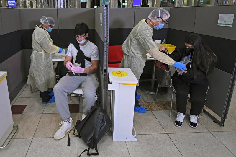 Health workers screen arrivals from London. AFP