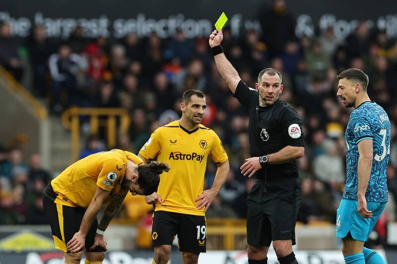 Wolves midfielder Ruben Neves is shown a yellow card by referee Tim Robinson. Getty
