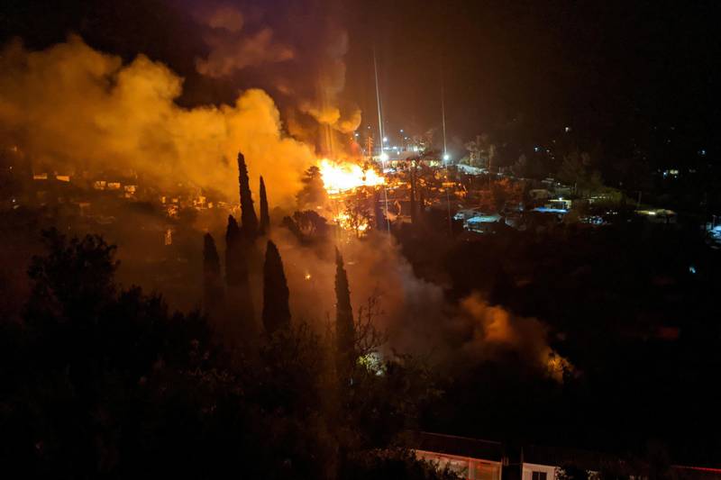 A fire burns at the migrant camp on the island of Samos, Greece, April 26, 2020. Picture taken April 26, 2020. Jose Cortez/Handout via REUTERS ATTENTION EDITORS - THIS IMAGE HAS BEEN SUPPLIED BY A THIRD PARTY.
