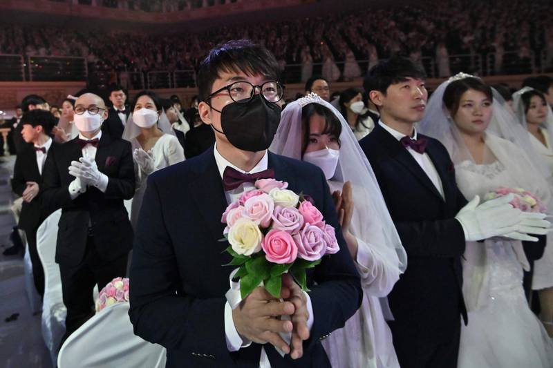 A couple wearing protective face masks attend a mass wedding ceremony organised by the Unification Church at Cheongshim Peace World Center in Gapyeong.  AFP