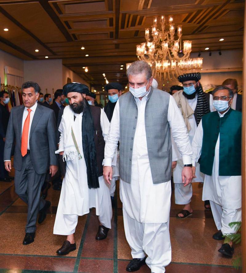 Pakistan's Foreign Minister Shah Mahmood Qureshi walks with Mullah Abdul Ghani Baradar (2nd L), the leader of the Taliban delegation, upon his arrival at the Ministry of Foreign Affairs (MOFA) office in Islamabad, Pakistan August 25, 2020. Ministry of Foreign Affairs (MoFA)/Handout via REUTERS/ATTENTION EDITORS - THIS PICTURE WAS PROVIDED BY A THIRD PARTY. NO RESALES. NO ARCHIVE. THIS IMAGE HAS BEEN SUPPLIED BY A THIRD PARTY.
