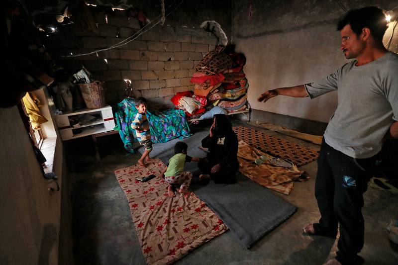 Issa Al Zamzoum, a father of five, with his family inside their home.