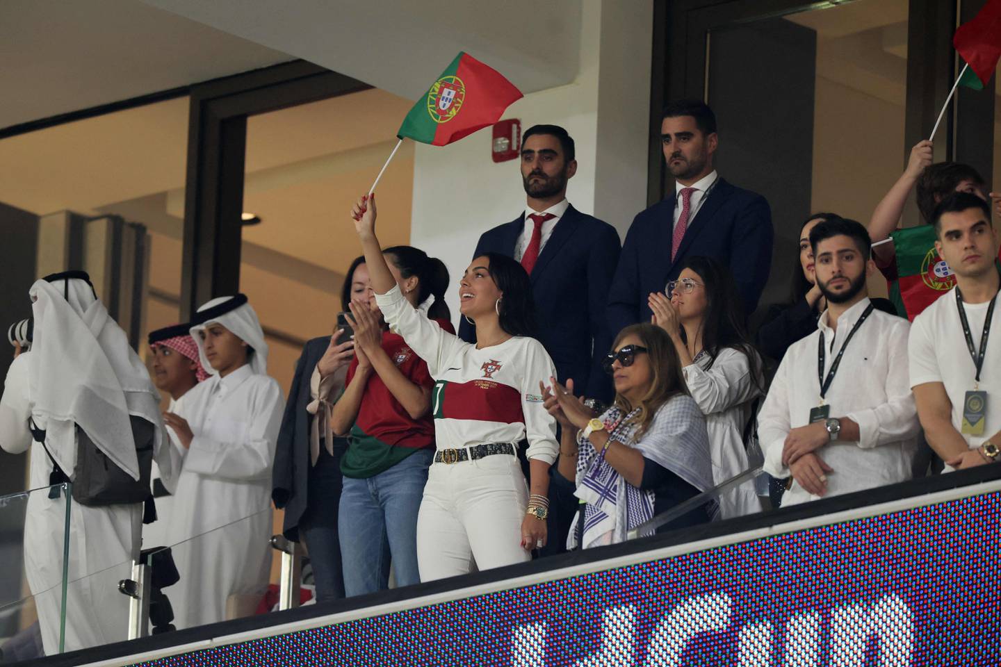 Georgina Rodriguez, centre, waves a Portugal flag before the start of the World Cup quarterfinal match between Morocco and Portugal at Al Thumama Stadium in Doha on December 10, 2022. AFP