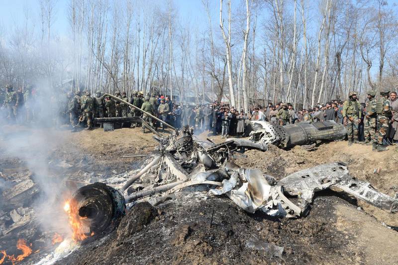 Indian soldiers and Kashmiri onlookers stand near the remains of an Indian Air Force aircraft after it crashed in Budgam district, 30 km from Srinagar.  AFP