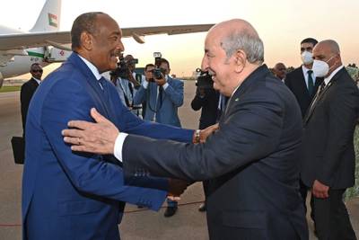 Mr Tebboune, right, welcomes Gen Al Burhan in Algiers. AFP