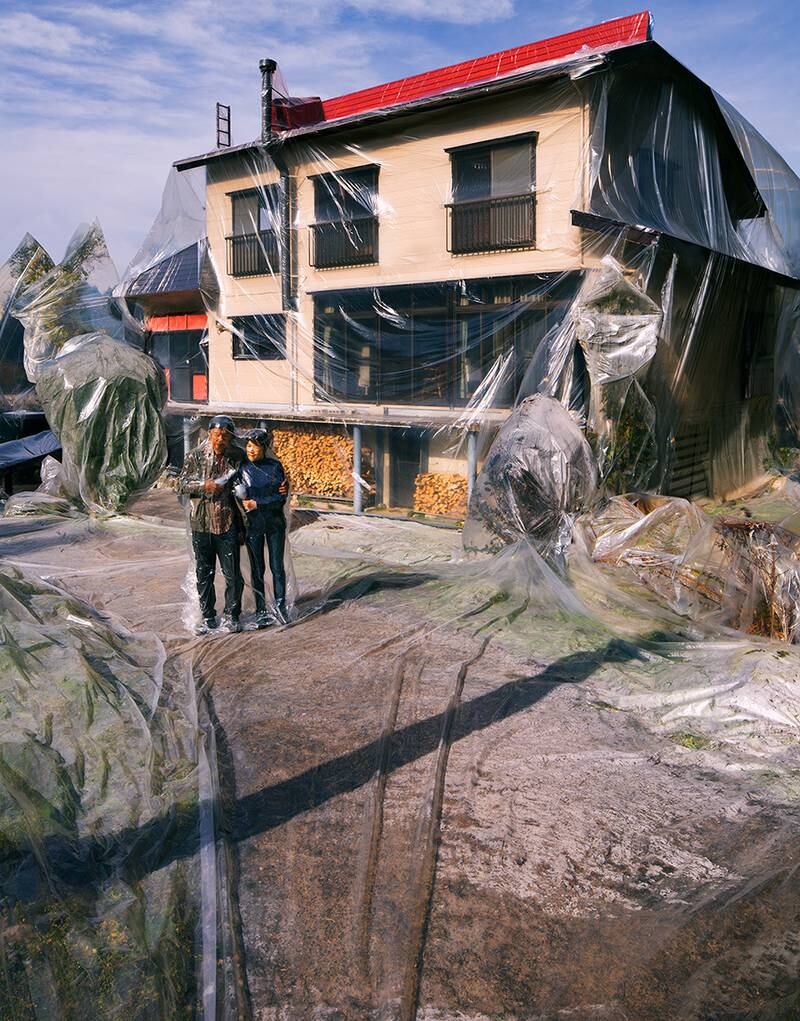 A couple shrink wrapped outside their home. 