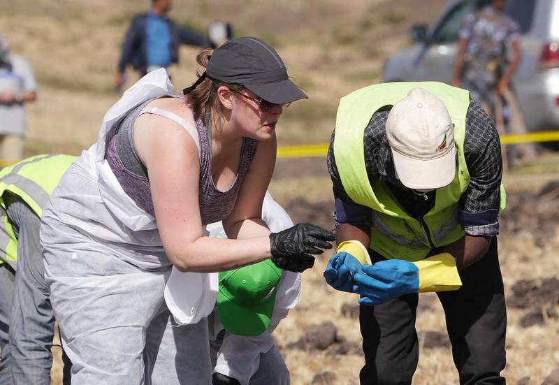 Forensic investigators and recovery teams collect personal belongings and other material from the crash site. Getty Images
