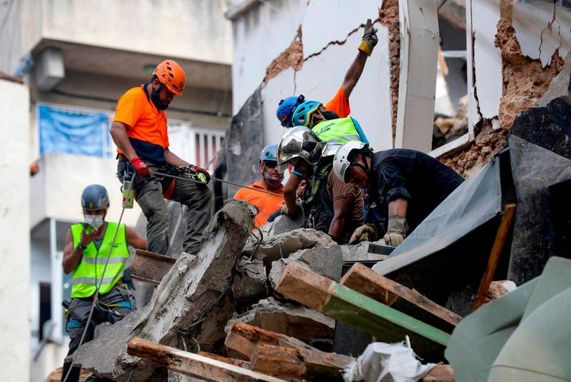 Rescue workers dig through the rubble of a badly damaged building in  Lebanon's capital Beirut in search of possible survivors from a mega-blast at the adjacent port one month ago. AFP