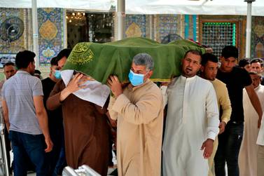 The coffin of a coronavirus patient killed in Saturday's hospital fire in Iraq's capital Baghdad is carried by mourners at the Imam Ali shrine in Najaf, on Sunday. AP