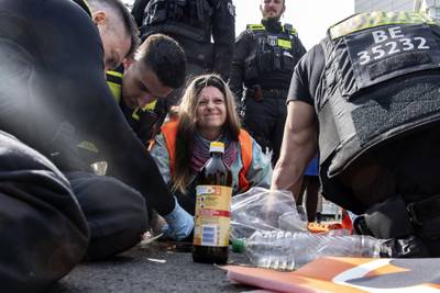 An activist is unglued from the road by police officers in Berlin. AP