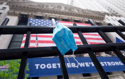 A face mask hangs on a fence in front of the New York Stock Exchange in New York. EPA