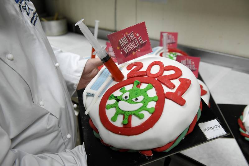 Greek pastry chef Marios Papadopoulos demonstrates a New Year's Day cake, known as Vasilopita, with its decoration inspired by the coronavirus disease (COVID-19) pandemic, in his pastry shop, in Thessaloniki, Greece, December 30, 2020. REUTERS/Alexandros Avramidis